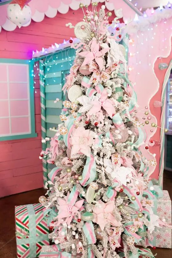 a flocked Christmas tree covered with white and pink fabric blooms, pastel green and pink ribbons, bows and beads is fun