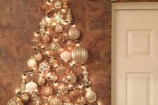 20 a glam wall-mounted Christmas tree done with lights and white and silver ornaments of various shapes over the mantel