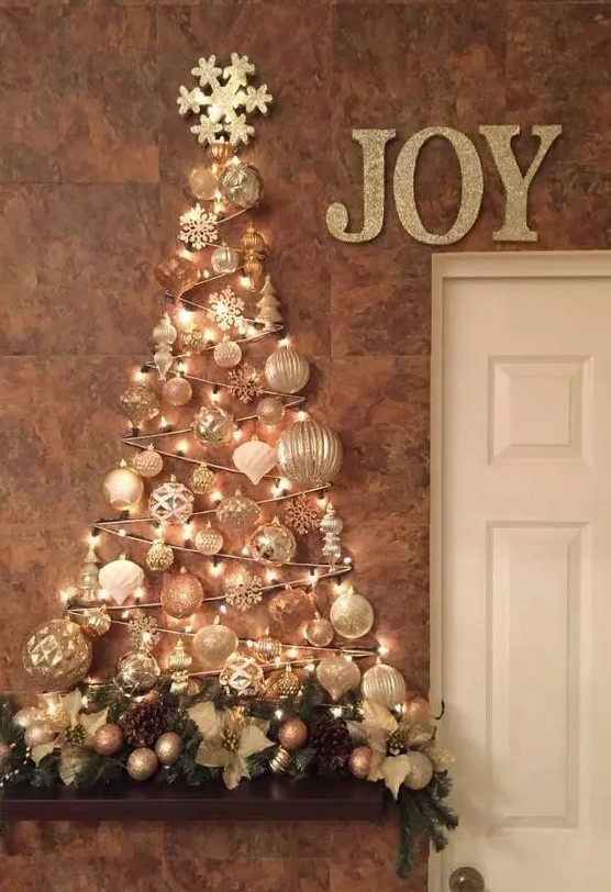 a glam wall mounted Christmas tree done with lights and white and silver ornaments of various shapes over the mantel