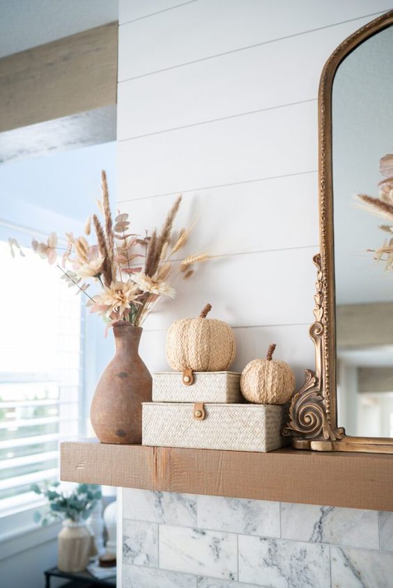 a boho Thanksgiving mantel with dried blooms and grasses, woven boxes and woven pumpkins is a lovely idea