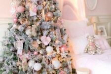 21 a flocked Christmas tree decorated with blush and pink ornaments, white snowflakes and stars and some paper decor