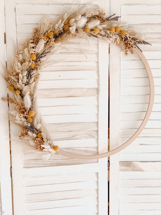 a boho Thanksgiving wreath of a wooden hoop, various dried grasses and blooms is a chic solution