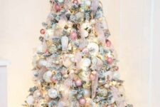 22 a flocked Christmas tree decorated with neutral, pink, silver ornaments, blush ribbon and a pink star topper