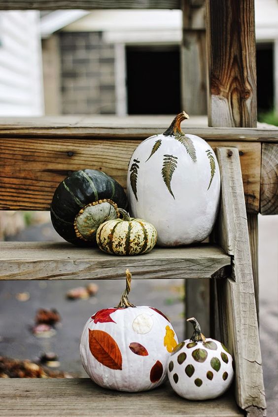 a pretty and natural fall or Thanksgiving pumpkin arrangement of white and natural pumpkins decorated with leaves is cool