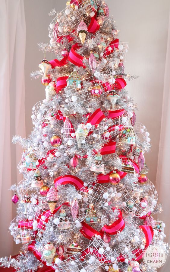 a silver Christmas tree with mesh ribbon and pompoms, red and pink rainbows and some vintage ornaments
