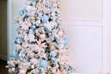 23 a flocked Christmas tree decorated with pastel pink and blush ornaments, pink fabric flowers and lights is gorgeous