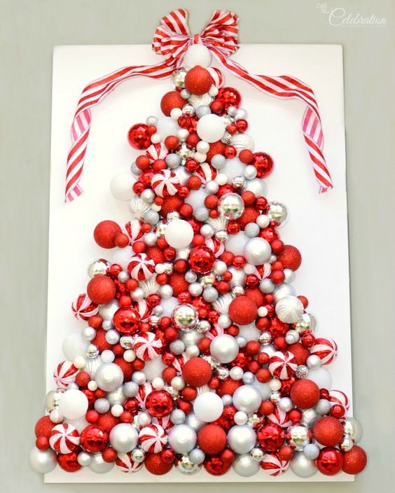a red and white Christmas tree art of various ornaments and a red and white ribbon bow on top