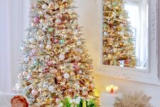 24 a flocked Christmas tree decorated with white, gold, pastel pink and green ornaments plus some metallic ones