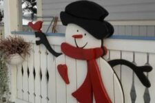 24 a plaque snowman attached to the porch fence is a lovely idea to add cuteness to your outdoor Christmas decor