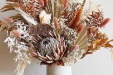 25 a bright boho Thanksgiving centerpiece with dried leaves, bunny tails and various blooms and fronds