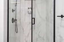 25 a chic shower space wiht large scale marble tiles, black frame glass doors and black fixtures is a lovely and cool space