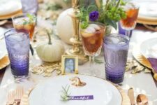 25 a refined gold and purple Thanksgiving tablescape with gold cutleyr, chargers and candlesticks, white pumpkins, greenery, purple glasses and napkins