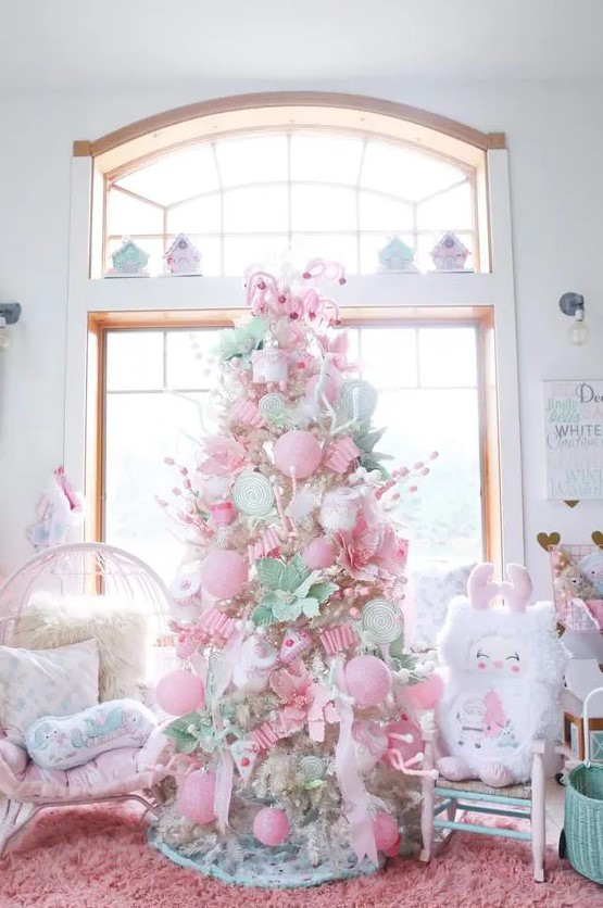 a neutral Christmas tree decorated with pink and pastel green ornaments, candy canes, faux blooms and cupcakes is amazing
