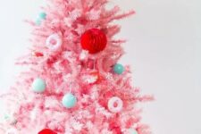 27 a pastel pink Christmas tree decorated with bold green, red, pastel blue ornaments and little donut ones is super cute