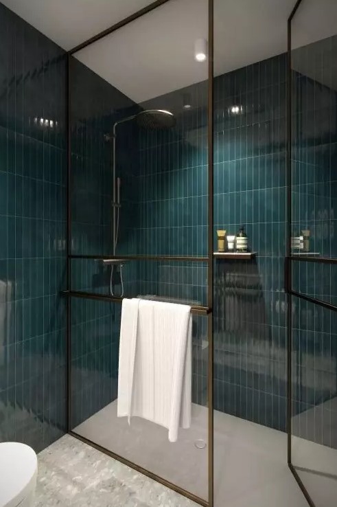 a shower space done with teal skinny tile, with black framed doors and a white floor is a bold and contrasting space