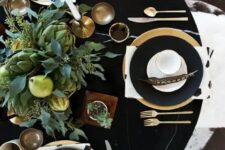 27 a stylish modern Thanksgiving tablescape in black, with a lush greenery, pears and artichoke centerpiece, black chargers and gold cutlery
