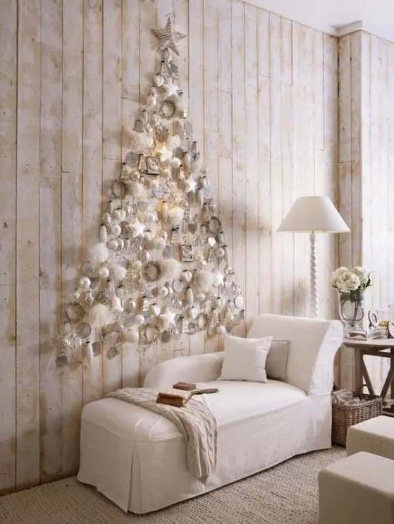a subtle white Christmas tree of white ornaments and fluffs plus a star on top is realized right on the wall