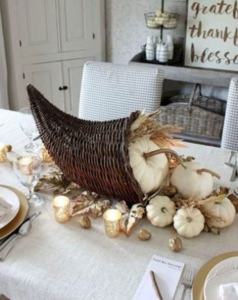 a cornucopia Thanksgiving centerpiece with white pumpkins, wheat and gold leaves plus nuts