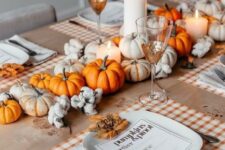 29 a cozy and bright Thanksgiving centerpiece of white and orange pumpkins, pillar candles and cotton