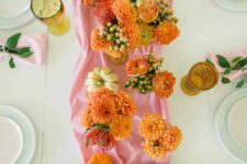 29 a pink and orange Thanksgiving table setting with a pink runner and orange blooms, orange and pink glasses and pink napkins
