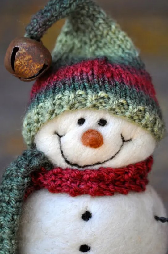 a white felt snowman in a red scarf, a green and red hat with a jingle bell is a very cute Christmas ornament you can make yourself