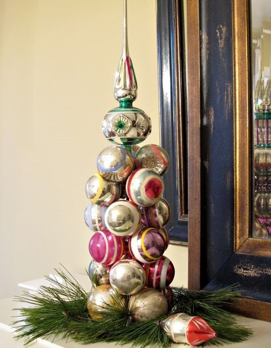 a bright tabletop Christmas tree of vintage ornaments, with evergreens under it is a lovely idea for a vintage celebration