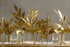 30 a wooden slab with gilded leaves, gold cutlery and gold touches for a chic and refined Thanksgiving tablescape