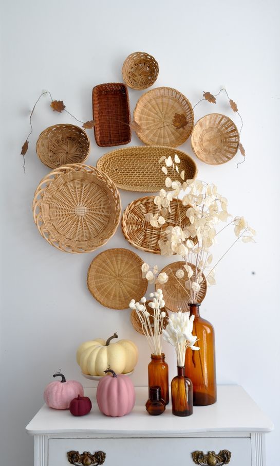 boho Thanksgiving decor with baskets on the wall, dried blooms and colored pumpkins is amazing