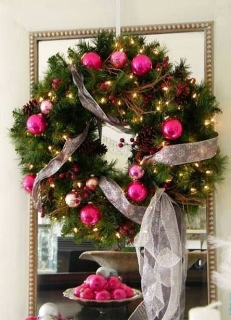 a Christmas wreath with hot pink, light pink and gold ornaments, neutral ribbons, berries and pinecones is amazing
