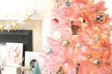 32 a pastel pink Christmas tree with metallic ornaments, lights and retro ones looks as a cute and chic touch of color