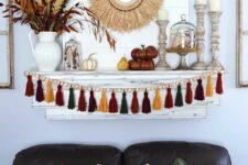 32 bright boho Thanksgiving decor with a bright tassel and wooden bead garland, wooden candleholders, a wheat wreath and soem bold branches