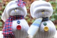 32 white snowmen of white stockings with colorful buttons and plaid scarves and hats are a cool and very easy Christmas craft