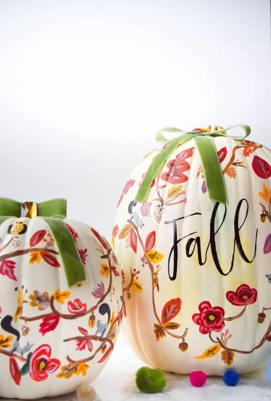white pumpkins decorated with pink, red and burgundy painted blooms and leaves and topped with green bows for the fall