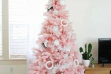 34 a pastel pink Christmas tree with skate and donut ornaments, pompoms and a shiny snowflake tree topper is amazing