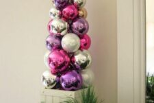 35 a bright tabletop Christmas tree composed of bold ornaments and topped with a silver star is a lovely idea for decor