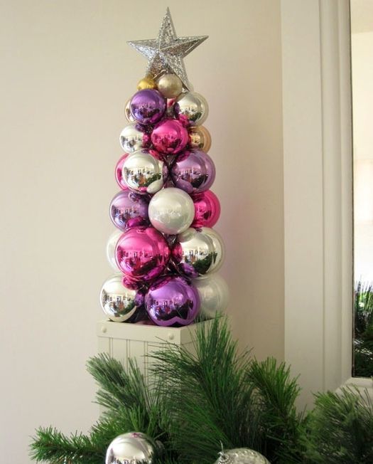 a bright tabletop Christmas tree composed of bold ornaments and topped with a silver star is a lovely idea for decor