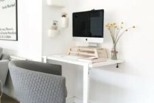 35 a working nook with a two-leg desk, a grey chair, a PC on a stand for more comfort and a series of box-like shelves