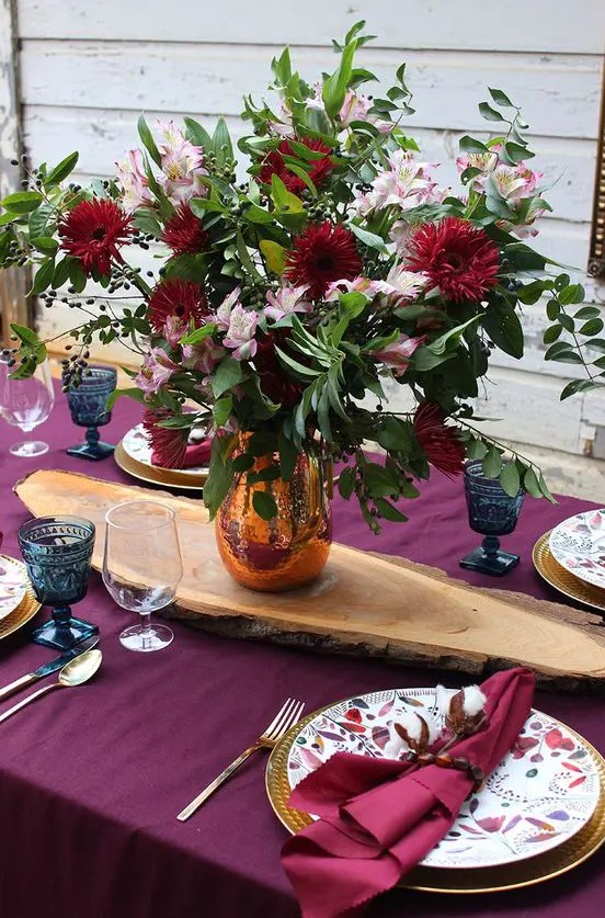go for a fuchsia tablecloth and napkins, bright blooms and gilded cutlery for Thanksgiving and enjoy the color