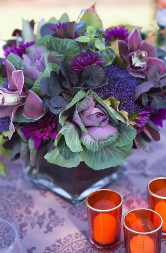 a unique Thanksgiving centerpiece of cabbage, purple blooms of various kinds, foliage and greenery is chic