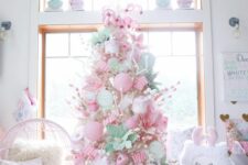 38 a white Christmas tree completely covered with pink, green and white ornaments, food-themed ones and usual baubles