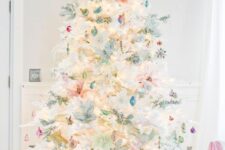 39 a white Christmas tree decorated with lots of various pastel ornaments, lights and an angel tree topper plus pastel gift boxes