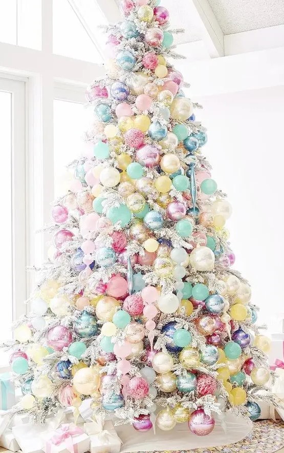 a white Christmas tree with pastel blue, yellow, pink, blush and other ornaments fully covering the tree and making it look fantastic