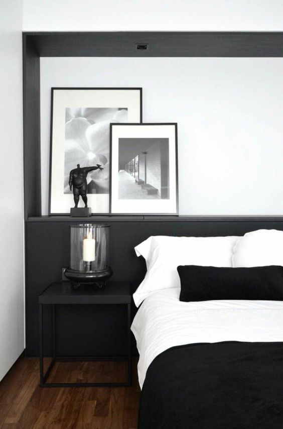 a black and white bedroom with black accents, a black nightstand and black and white bedding is cool and cozy