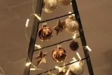a blackened metal frame Christmas tree with lights, white, copper and brown ornaments plus candles at the base is a cool idea
