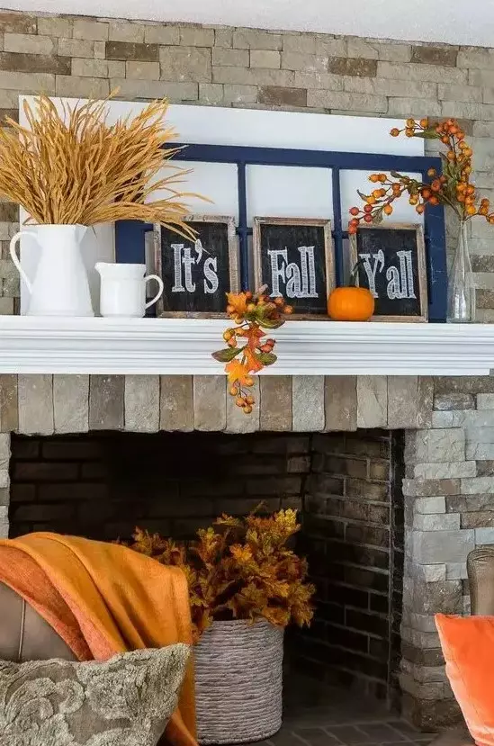 a bright and simple Thanksgiving mantel with wheat in a jug, chalkboard signs, window frames, bold pumpkins and fruits