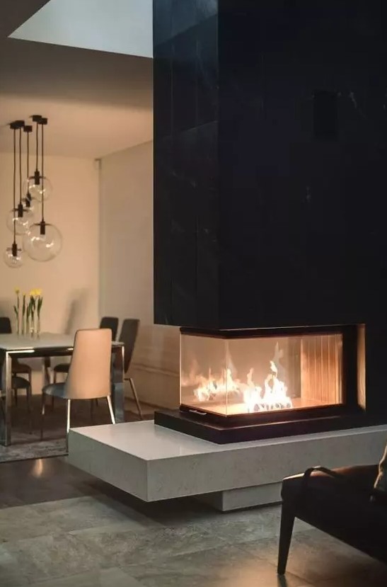 a contemporary built in fireplace with a sleek black tile top and a light colored stone base is a bold contrasting idea to rock