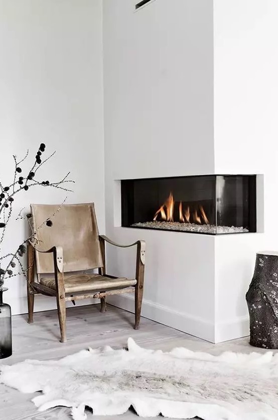 a cozy minimalist nook with a fireplace built into the corner to make the space more spectacular and see more of the fire
