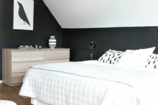 a dreamy attic bedroom with black walls and a white ceiling, a white bed with neutral bedding and a stainder dresser