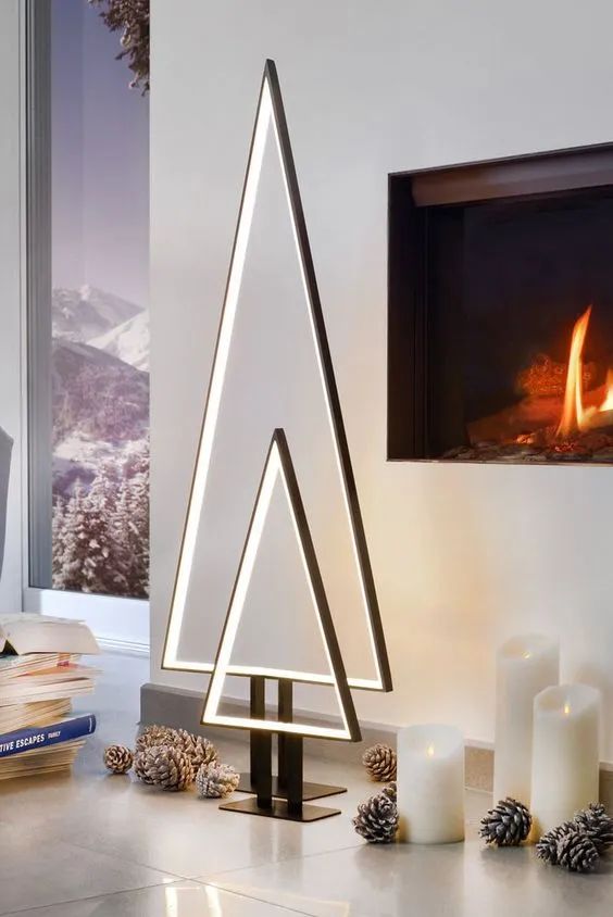 a duo of minimalist lit up frame Christmas trees plus pinecones on the floor is a super chic and bold idea to rock