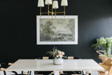 a laconic and welcoming dining room with a black accent wall, a white table and black chairs, an artwork and some greenery